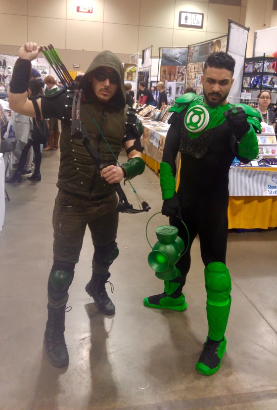 Two cosplayers, one dressed up as Green Arrow and the other as Green Lantern from DC Comics.