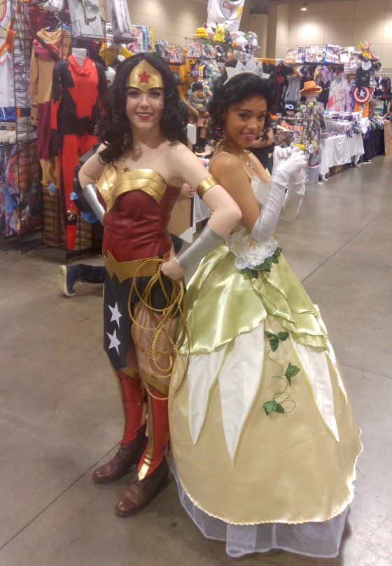 Two cosplayers, one as Wonder Woman from DC Comics, the other as Princess Tiana from Disney's The Princess and the Frog.